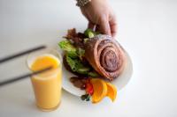 un plato con un sándwich y un vaso de zumo de naranja en Unstad Arctic Resort, en Unnstad