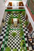 a room with a checkered floor with potted plants at Pensión San Benito Abad in Seville