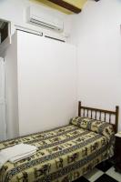 a bed in a room with avertisementatronatronstrationstrationstration at Pensión San Benito Abad in Seville