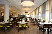 ein Esszimmer mit Tischen und Stühlen und Fenstern in der Unterkunft U Magic Palace in Eilat