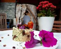 a piece of cake on a plate on a table with flowers at Le Rocher Hotel in Champoluc