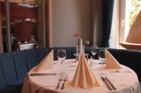 Una mesa con copas de vino y una rosa roja sobre ella. en Hotel Schlösschen Sundische Wiese Zingst, en Zingst