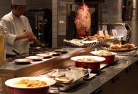 a chef preparing food in a restaurant kitchen at Loisir Spa Tower Naha in Naha