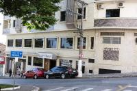 a building with two cars parked in front of it at Kafé Hotel in Guaratinguetá