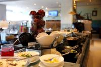 a buffet line with plates and bowls of food at Peerless Hotel Kolkata in Kolkata