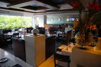 a restaurant with tables and chairs and a vase of flowers at Peerless Hotel Kolkata in Kolkata