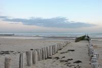 a beach with a wooden fence in the sand at City2Beach Hotel in Vlissingen