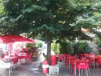 a group of red tables and chairs under a tree at Casa Es Neres in Les