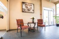 two chairs and a table with a vase of flowers at Stop Hotel in Braşov