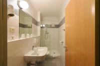 a white bathroom with a sink and a shower at Hotel Korotan in Vienna