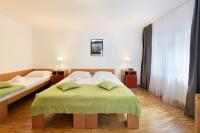 a hotel room with two beds with green sheets at Hotel Korotan in Vienna