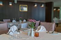 uma mesa com copos de vinho e flores em Kriti Beach Hotel em Retimno