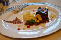 a white plate with a piece of cake and ice cream at Gasthof Ziegler Hotel & Restaurant in Lindau