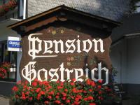 a sign for a restaurant with flowers in front of it at Pension Gastreich in Lennestadt