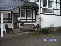 a black and white house with a porch and stairs at Pension Gastreich in Lennestadt