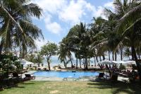 a pool at the beach with palm trees and the ocean at Peppercorn Beach Resort in Phú Quốc