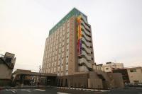 Un edificio alto con un cartel al costado. en Hotel Route-Inn Koga Ekimae, en Koga