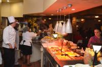 eine Gruppe von Menschen, die in einer Küche stehen und Essen zubereiten in der Unterkunft Gooderson Drakensberg Gardens Golf & Spa Resort in Drakensberg Garden