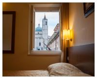 Un dormitorio con una ventana con vista a un edificio. en Residenza dei Capitani, en Ascoli Piceno