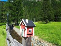 a red bird house sitting on a stone wall at Le Rocher Hotel in Champoluc