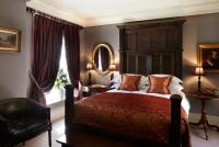a bedroom with a bed and a chair and a mirror at The Rookery in London