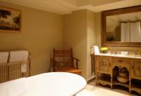 a bathroom with a bed and a sink and a mirror at The Rookery in London