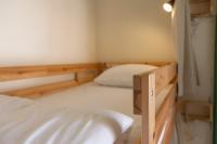 a small bedroom with a bed and a sink at Sleeping Boot Hostel in Hualien City