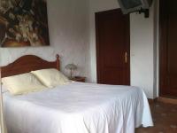 a bedroom with a white bed and a painting on the wall at Xanadu Rural in Chiclana de la Frontera