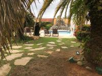 a yard with palm trees and a swimming pool at Pousada Casa do Catavento in Búzios