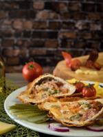 a plate of food with sandwiches and tomatoes on a table at Land-Plan Hotel in Töltéstava