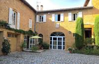 a large brick building with a courtyard in front of it at Le Clos des Pierres Dorées in Theizé