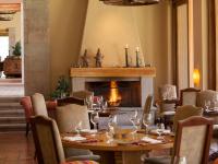 Un comedor con mesa y chimenea. en Inkaterra Hacienda Urubamba, en Urubamba