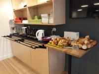 a kitchen with a counter with a plate of bread at La Godinière in Cholet