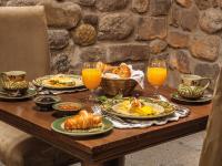una mesa con platos de comida y vasos de jugo de naranja en Inkaterra La Casona Relais & Chateaux, en Cusco
