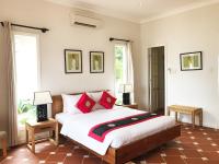 a bedroom with a large bed with red pillows at Peppercorn Beach Resort in Phú Quốc