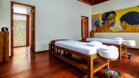 two beds in a room with a painting on the wall at Qunci Villas Resort in Senggigi