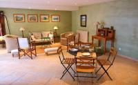 a living room with chairs and a table and a couch at Le Clos des Pierres Dorées in Theizé
