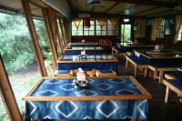 Un comedor con mesas y ventanas azules. en Zhou Ye Cottage, en Sanyi