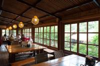 Un comedor con mesas y ventanas y gente. en Zhou Ye Cottage, en Sanyi