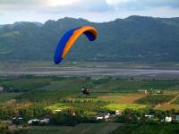 a person flying a parachute in the air at Slowly B&amp;B in Taitung City
