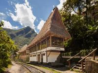 un edificio con techo de paja junto a las vías del tren en Inkaterra Machu Picchu Pueblo Hotel, en Machu Picchu