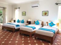 a room with three beds with blue pillows at Peppercorn Beach Resort in Phú Quốc