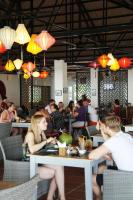 a group of people sitting at tables in a restaurant at Peppercorn Beach Resort in Phú Quốc