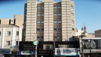 Un edificio alto con un mural en el costado. en Hotel Premium Flat Ourinhos, en Ourinhos