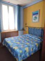- une chambre avec un lit bleu et jaune et 2 fenêtres dans l&#39;établissement Hotel De Provence, à Digne-Les-Bains