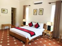 a bedroom with a large bed and two lamps at Peppercorn Beach Resort in Phú Quốc