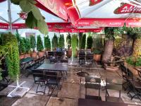 a restaurant with tables and chairs and plants at Hotel Barbaris in Kyiv