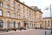 un gran edificio de ladrillo con banderas delante en Great Victoria Hotel, en Bradford