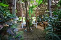 een kas met mensen die aan tafels zitten en planten bij Watermill Resort in Nong Nam Daeng