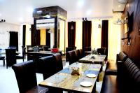 een restaurant met tafels en stoelen in een kamer bij Taraji Resort in Ayodhya